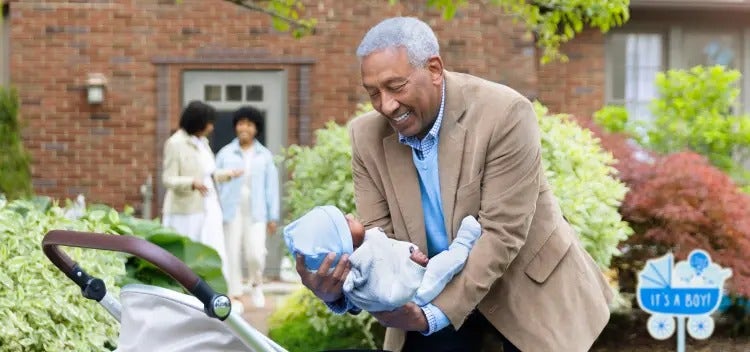 Image of a grandfather placing a baby in a carriage, as a grandmother and mother talk in the background (not real patients) mobile