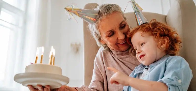 Image of a grandmother looking at a child blowing out candles on a cake (not real patients) mobile