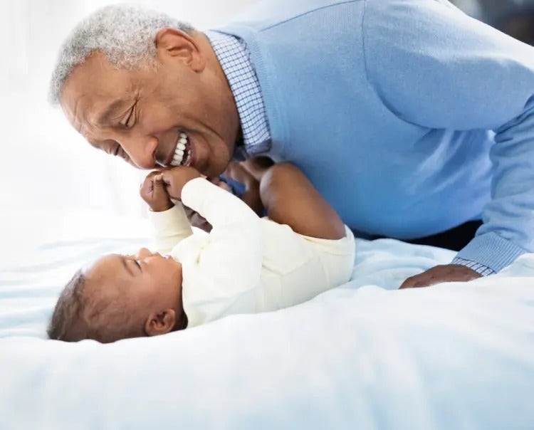 Image of grandfather playing with a baby (not real patients) mobile
