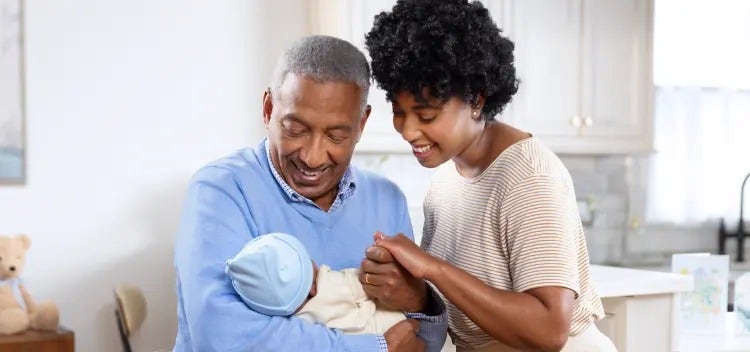Image of a grandfather and mother looking at a baby (not real patients) mobile