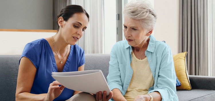 Image of a woman explaining a personalized patient brochure to an older woman (not real patients)