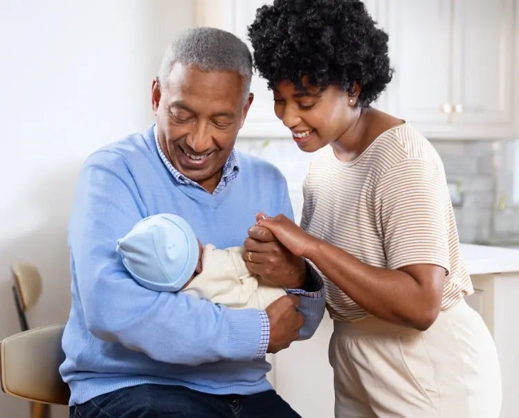 Image of a grandfather and mother looking at a baby (not real patients) mobile