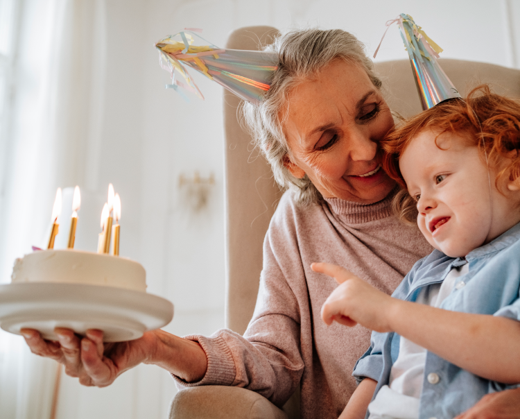 Image of a grandmother looking at a child blowing out candles on a cake (not real patients) mobile
